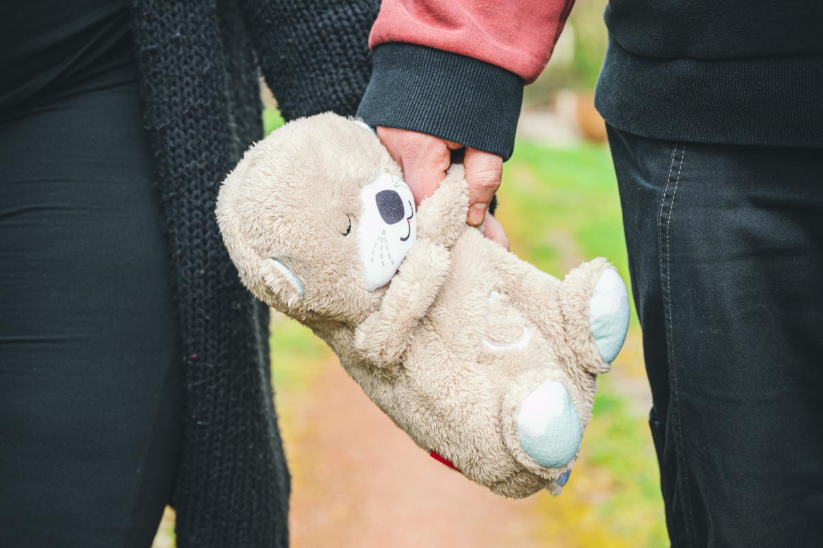 Ein junges Paar halten den Teddy für ihr bald kommendes Baby.
