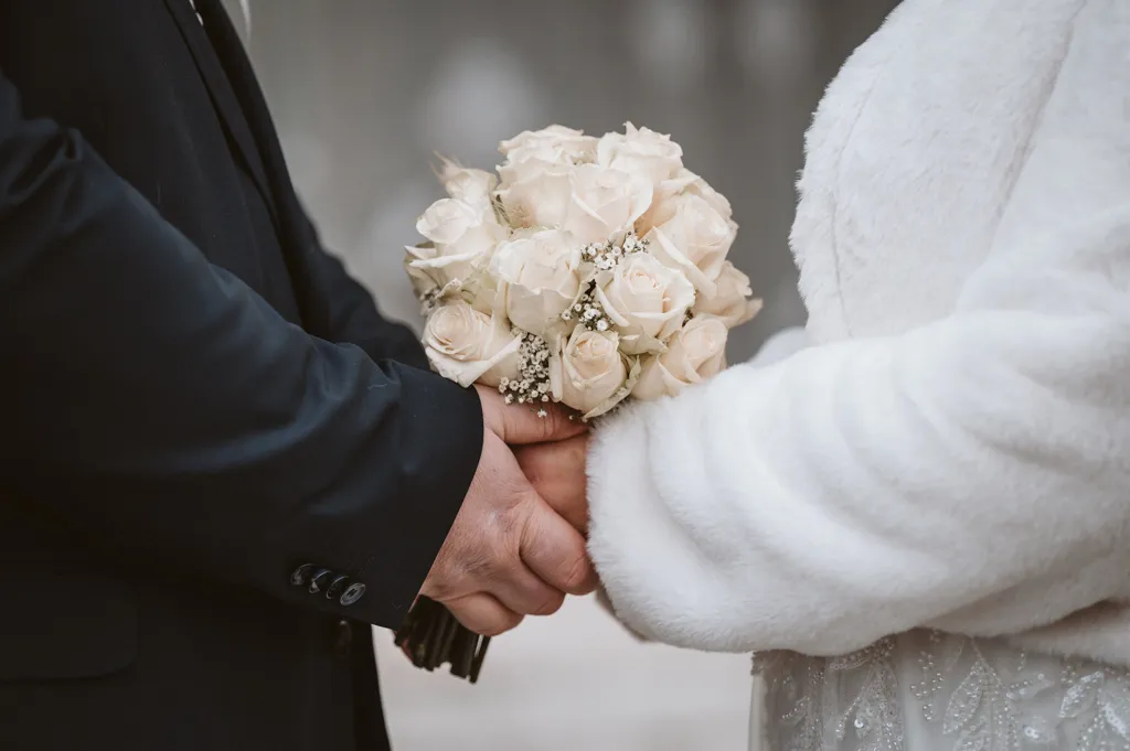 Gemeinsames Glück und der Brautstrauß Braut und Bräutigam halten gemeinsam den bunten Brautstrauß nach der Trauung in Fürstenfeldbruck. Ein Moment der Zweisamkeit und Freude.
