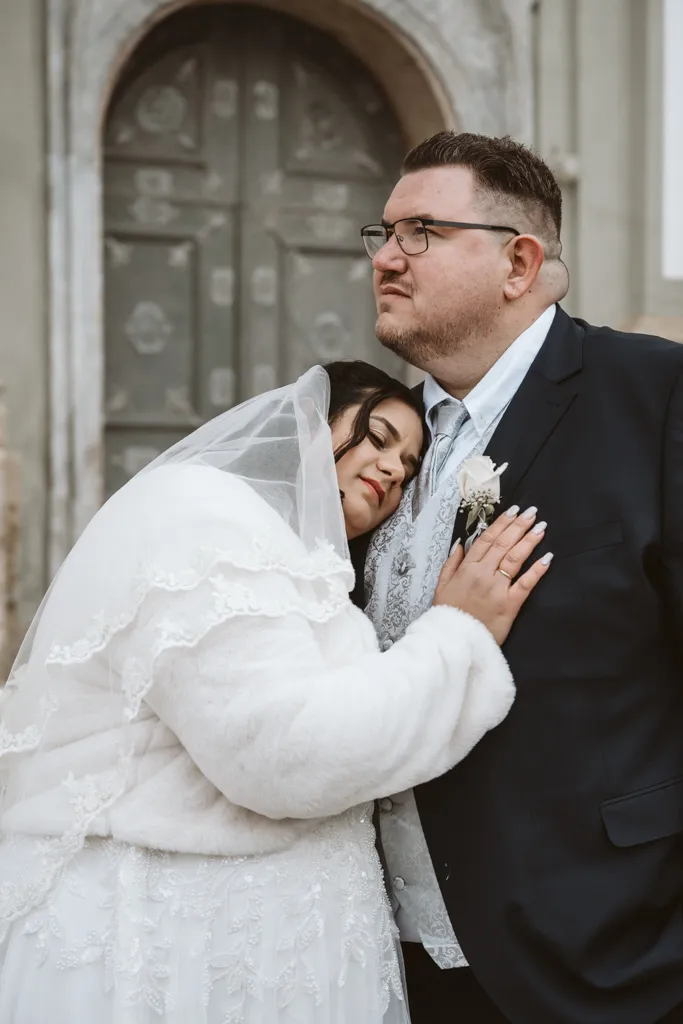 Ein Moment voller Ruhe und Vertrauen Inniges Brautpaar-Porträt am Kloster Fürstenfeld: Die Braut lehnt ihren Kopf an die Brust des Bräutigams – Moment der Geborgenheit.