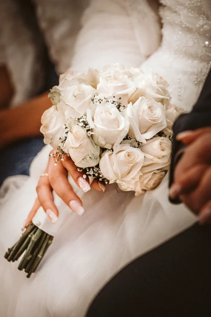 Brautstrauß Detailaufnahme Nahaufnahme eines eleganten Brautstraußes, gehalten von der Braut in ihrem Hochzeitskleid. Fokus auf die floralen Details der Hochzeitsfloristik.