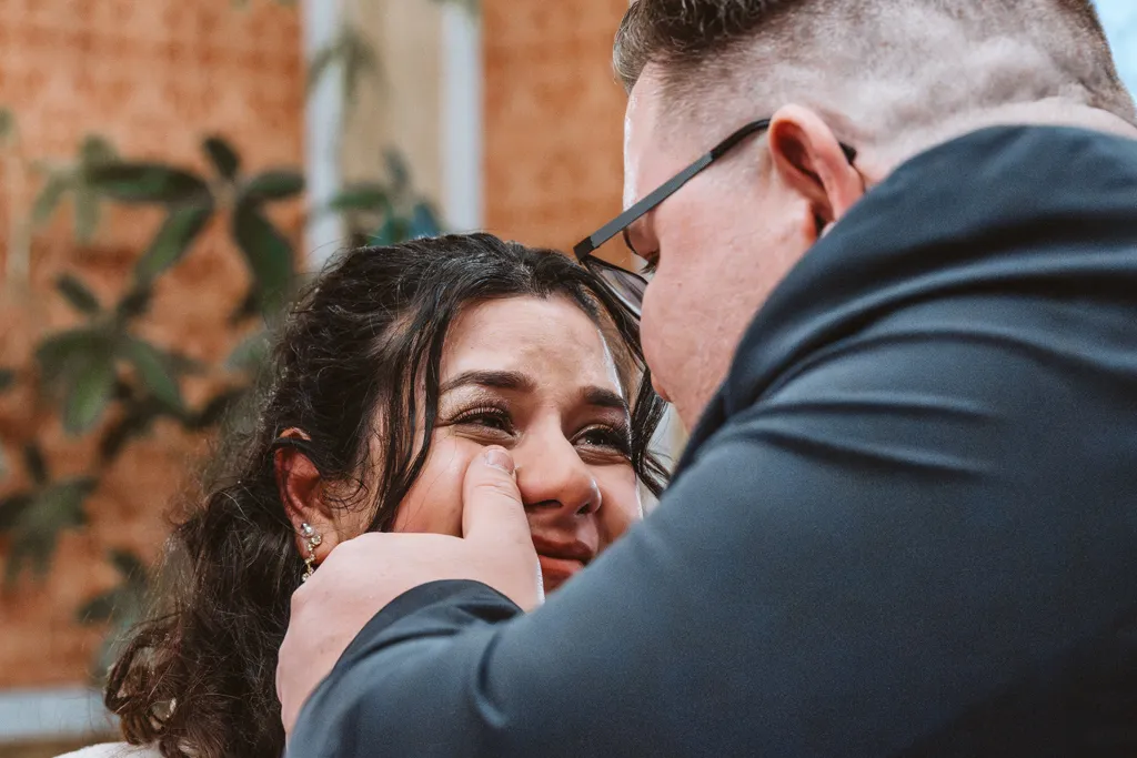 Ein Augenblick voller Liebe und Geborgenheit Liebevolles Detail der Hochzeitsreportage: Der Bräutigam wischt der Braut während der Trauung eine Freudenträne von der Wange.