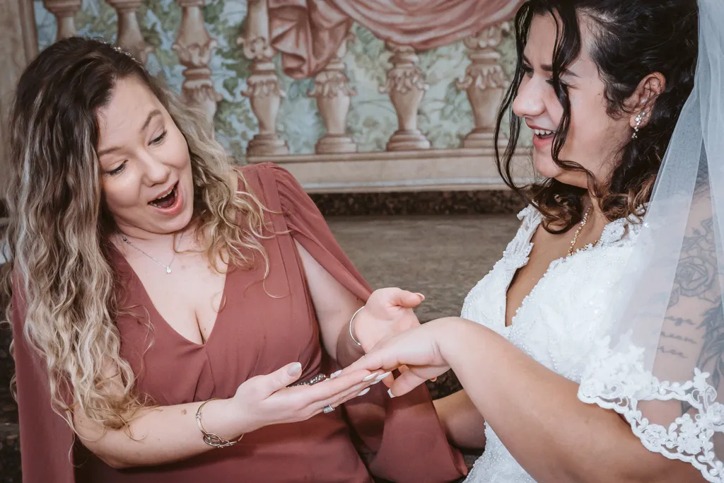 Stolz und Freude: Die Braut präsentiert ihren Ring Stolze Braut zeigt einem weiblichen Gast ihren Ehering. Ein herzlicher und emotionaler Moment während der Hochzeitsfeier.