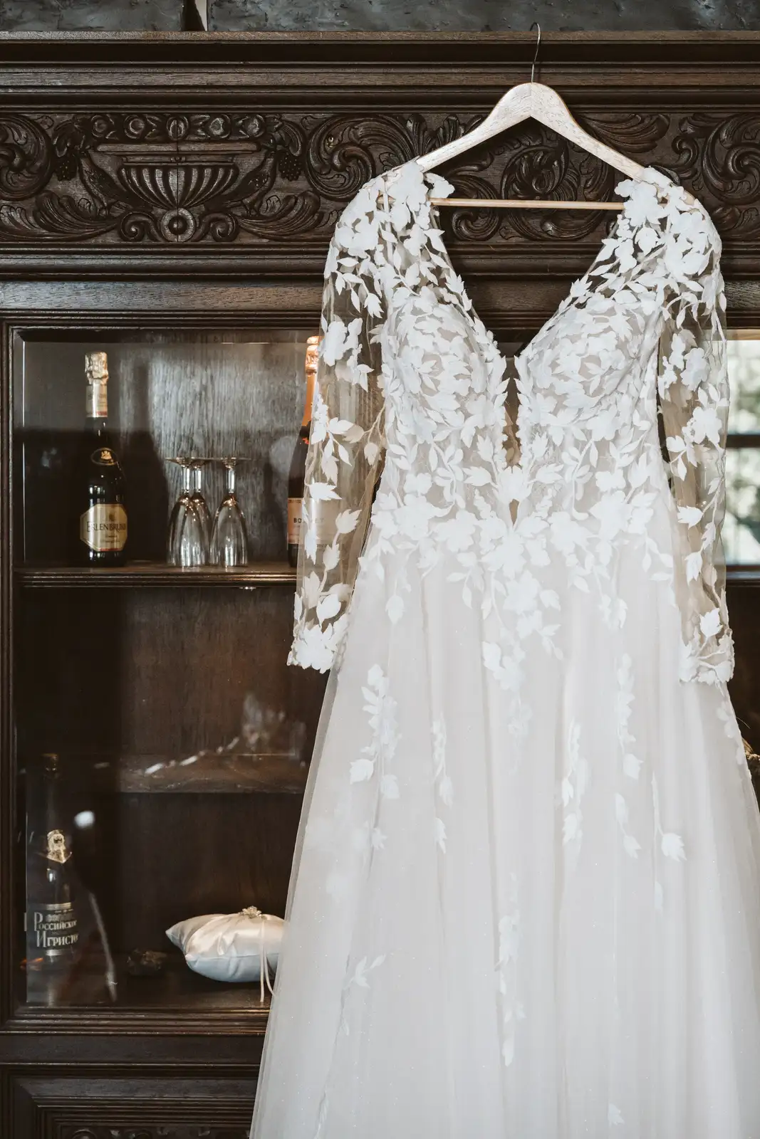 Getting Ready – Brautkleid am Schrank im Schloss Brautkleid hängt beim Getting Ready an einem Holzschrank im Schlossraum