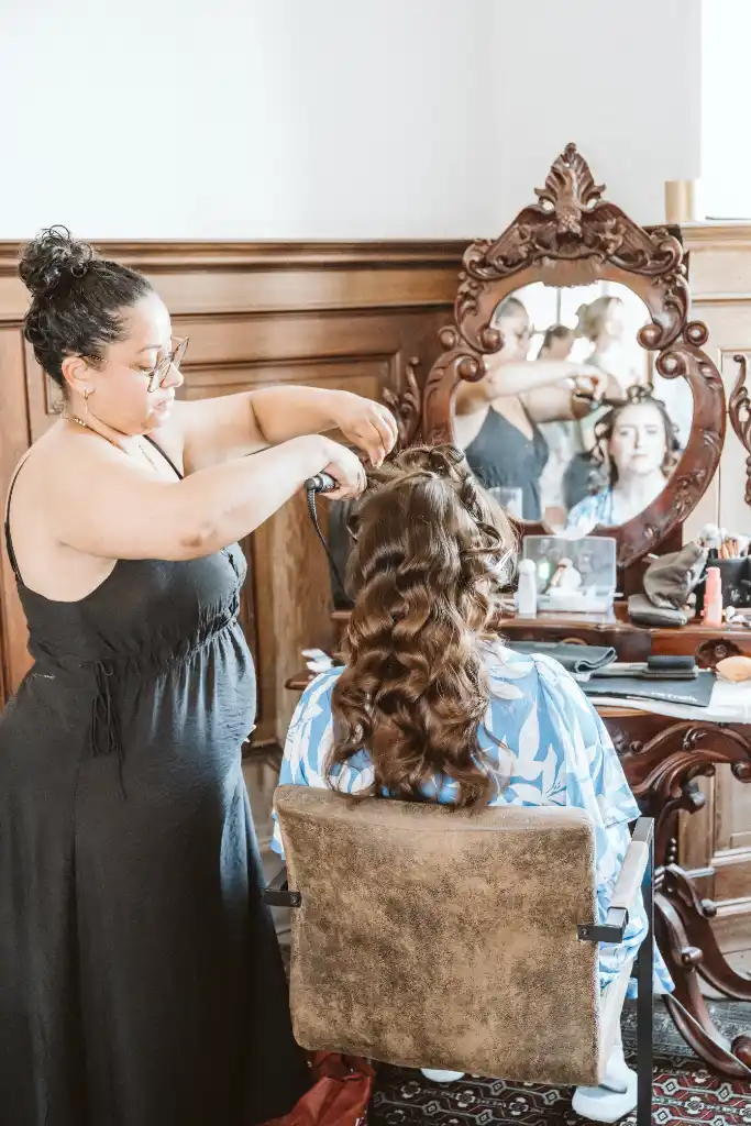 Getting Ready – Haarstyling der Braut Brautfrisur wird beim Getting Ready im Schlossraum für die Trauung gestylt