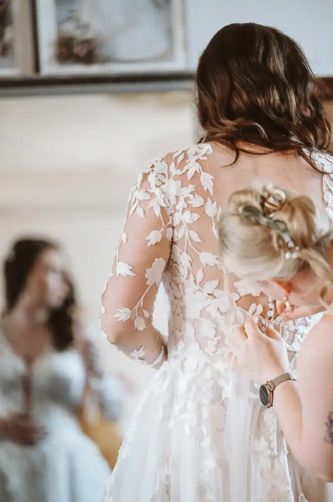 Getting Ready – Brautkleid wird zurechtgerichtet Brautkleid wird beim Getting Ready für die Trauung zurechtgerichtet