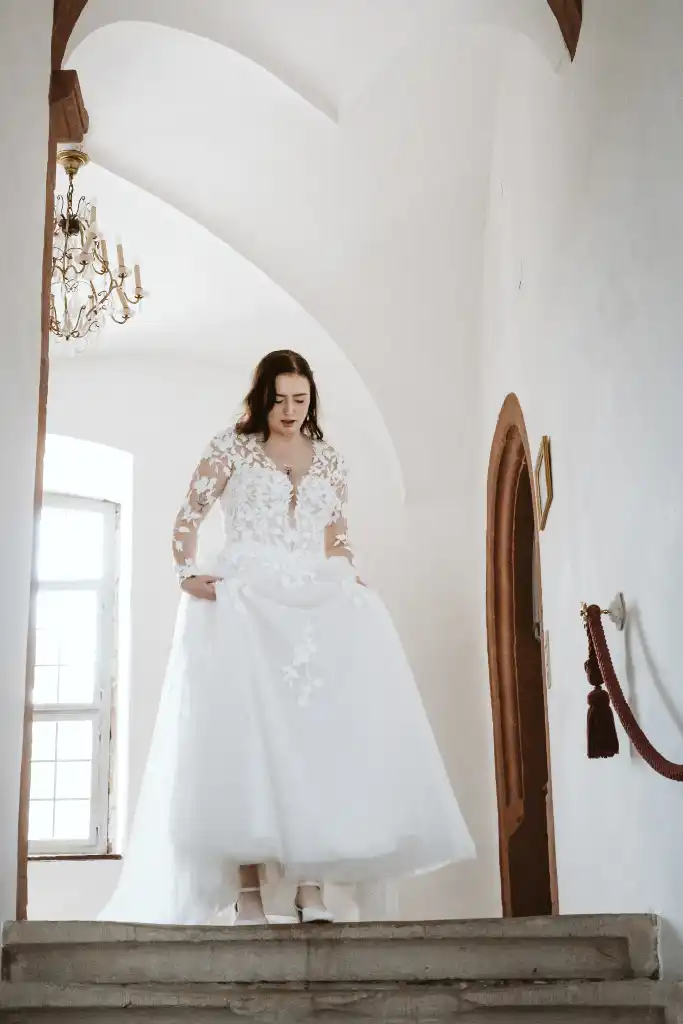 Getting Ready – Braut geht die Treppe hinunter Braut schreitet im Brautkleid die imposante Schlosstreppe hinunter