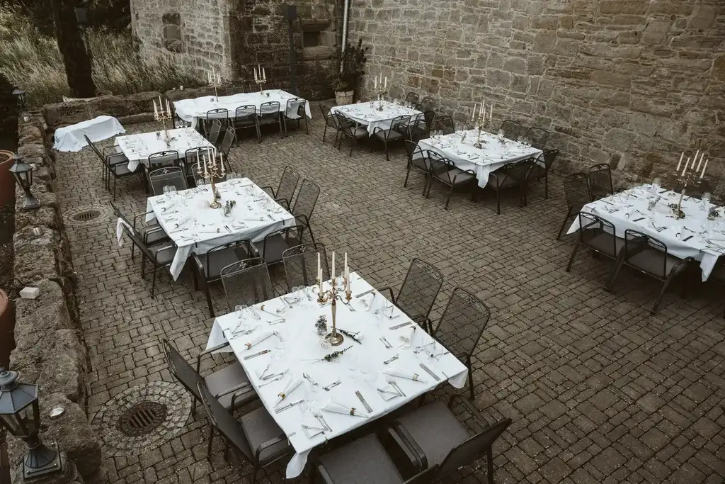 Hochzeitsdeko – Festlich gedeckte Tische vor der Feier Elegant gestaltete Tischdekoration mit Blumen und Kerzen auf den festlich gedeckten Tischen