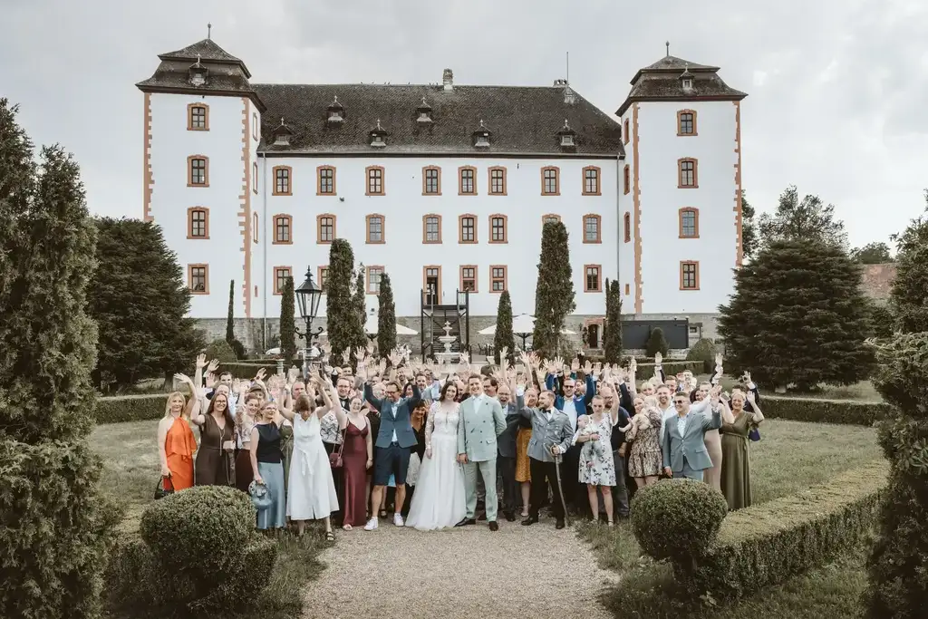 Hochzeitsgesellschaft – Gruppenbild mit dem Brautpaar Gruppenaufnahme aller Hochzeitsgäste zusammen mit dem strahlenden Brautpaar