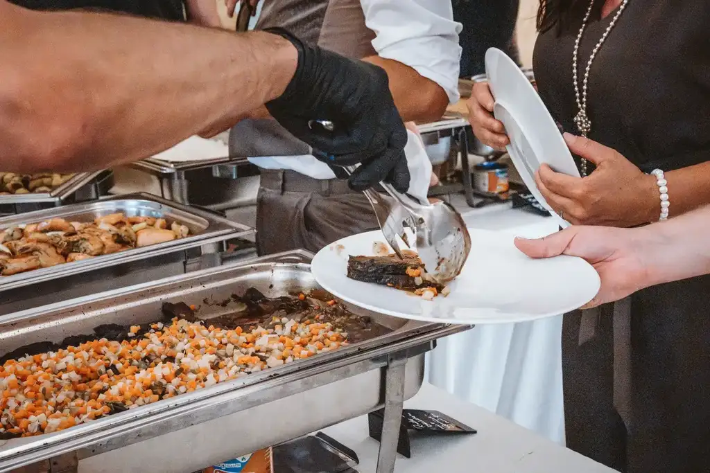 Hochzeitsessen – Servieren der Speisen durch den Service Zuverlässiges Servicepersonal serviert den Hochzeitsgästen elegant die frisch zubereiteten Gänge