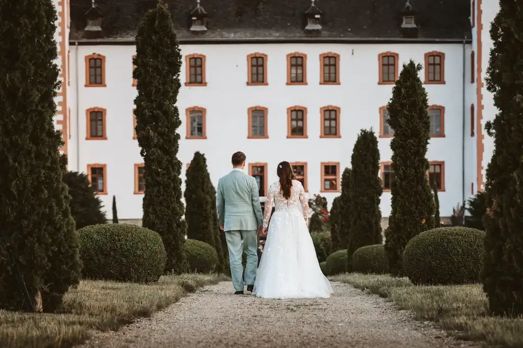 Brautpaar-Shooting – Symbolischer Schritt in die gemeinsame Zukunft Das Brautpaar geht Hand in Hand einen malerischen Pfad entlang und symbolisiert den gemeinsamen Lebensweg