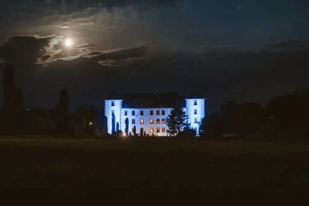 Hochzeitslocation – Romantische Atmosphäre an der beleuchteten Burg bei Nacht Die beleuchtete Burg ragt eindrucksvoll in den nächtlichen Himmel und sorgt für eine stimmungsvolle Kulisse der Hochzeitsfeier