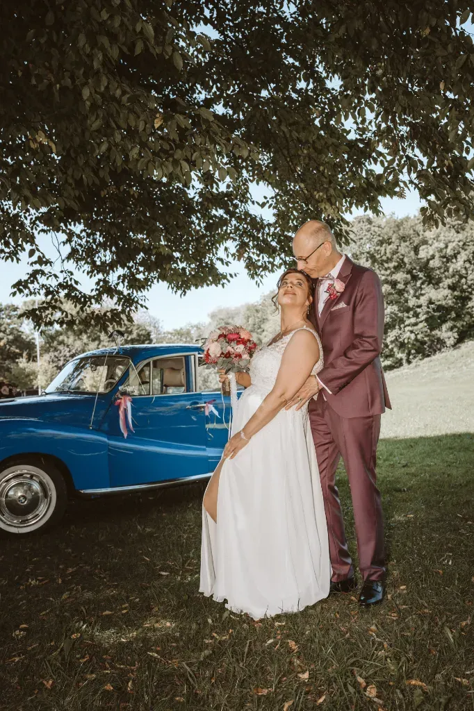 Romantisches Portrait: Bräutigam stützt die Braut Fotograf Olching: Romantisches Portrait des Brautpaares. Der Bräutigam stützt die Braut von hinten, während sie liebevoll zu ihm hinaufblickt.