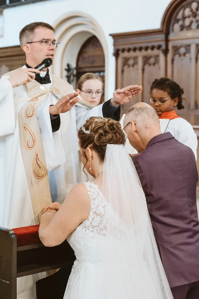 Segnung: Brautpaar kniet vor dem Priester Fotograf Olching: Sakraler Moment, bei dem das Brautpaar vor dem Priester kniet. Der Priester spendet dem Paar in der Kirche in Olching den Segen