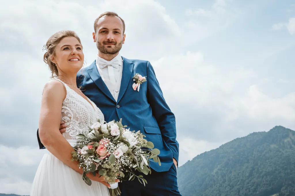 Brautpaar-Foto vor Bergspitze, Bräutigam sieht den Betrachter an, Braut blickt in die Ferne.