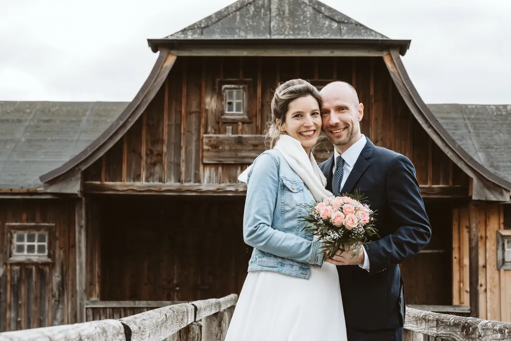 Romantisches Fotoshooting eines Brautpaares vor einem idyllischen Bootshaus.
