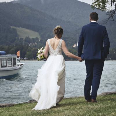 Hochzeitspaar am Ufer, während ein Schiff vorbeifährt