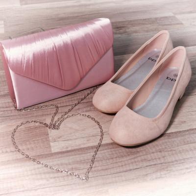 Eine rosa Brauttasche mit herzförmiger Kette und passende Schuhe.